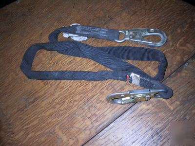 Shock absorbing lanyard fall arrest safety harness